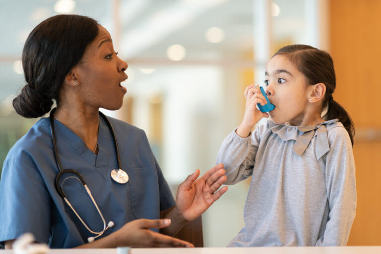 Female doctor assists young asthmatic patient