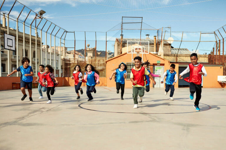 A group of young boys and girls is running to prepare for their school sports physical.